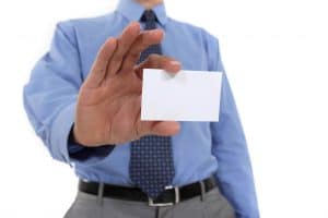 A business man holding out a blank card whilst he thinks of a business name