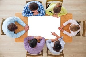 A group of people sat around a table looking at an empty canvas of content ideas