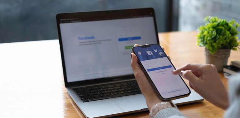 A picture of a mobile phone and computer showing the facebook login screen