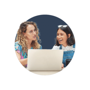 Two business owners sat at a laptop, discussing the 5 areas you should never skimp on when starting a business.