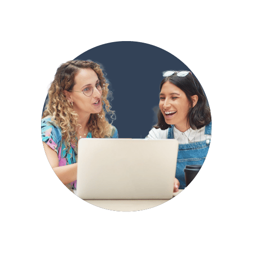 Two business owners sat at a laptop, discussing the 5 areas you should never skimp on when starting a business.
